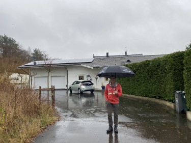 Max framför sitt hus med solpaneler och batterier