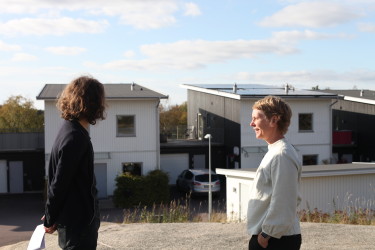 Erik från Solcellskollen och Lisa står framför familjen Lundins nyinstallerade solcellssystem.